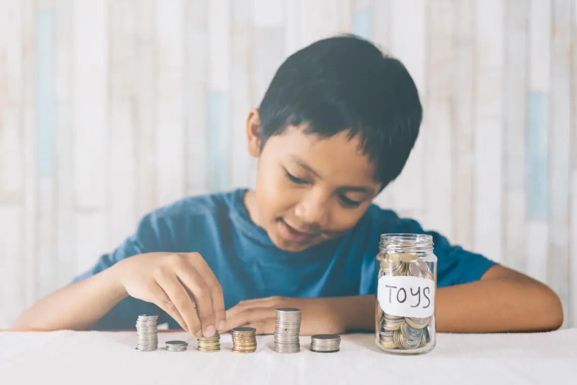 Seorang anak kecil sedang menyisihkan uangnya untuk di tabung