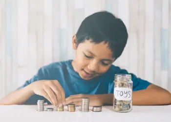 Seorang anak kecil sedang menyisihkan uangnya untuk di tabung