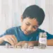 Seorang anak kecil sedang menyisihkan uangnya untuk di tabung