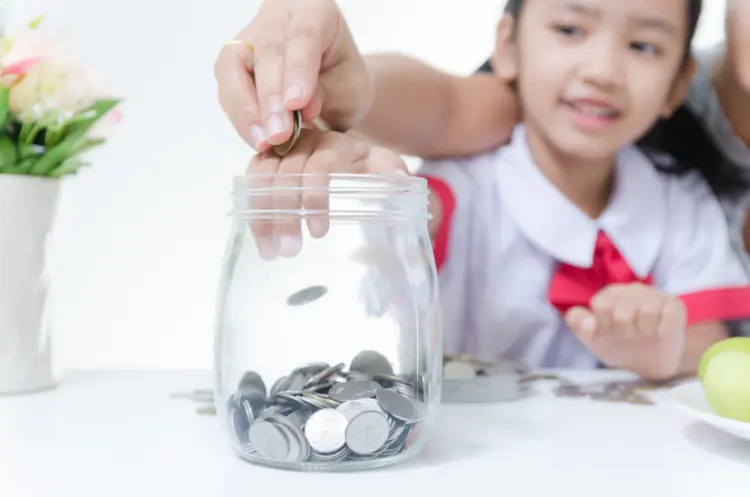 Seorang anak sedang di ajarkan menabung oleh orang tuanya