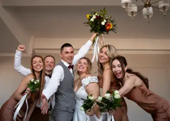 Sepasang mempelai wanita dan laki-laki sedang ceria pada resepsi pernikahan mereka.