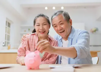 sepasang lansia sedang melakukan rencana bisnis dana pensiun dengan menabung.