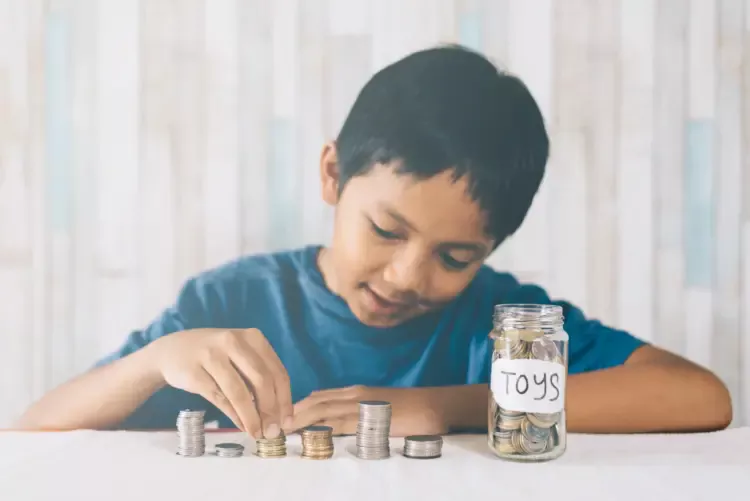 Seorang anak kecil sedang menyisihkan uangnya untuk di tabung