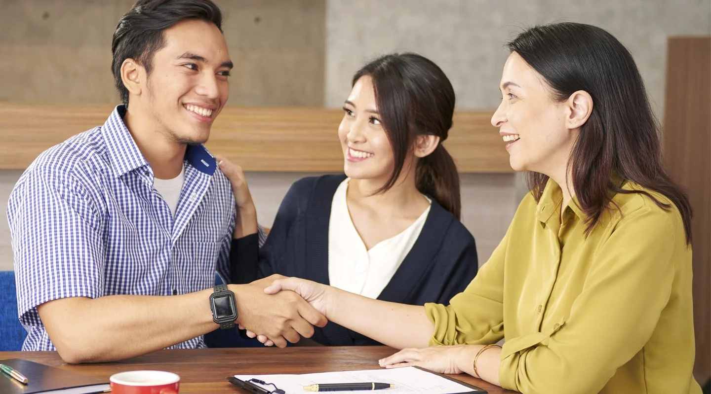 Tiga orang berjabat tangan di meja kantor, banner BCA Business Debit Card