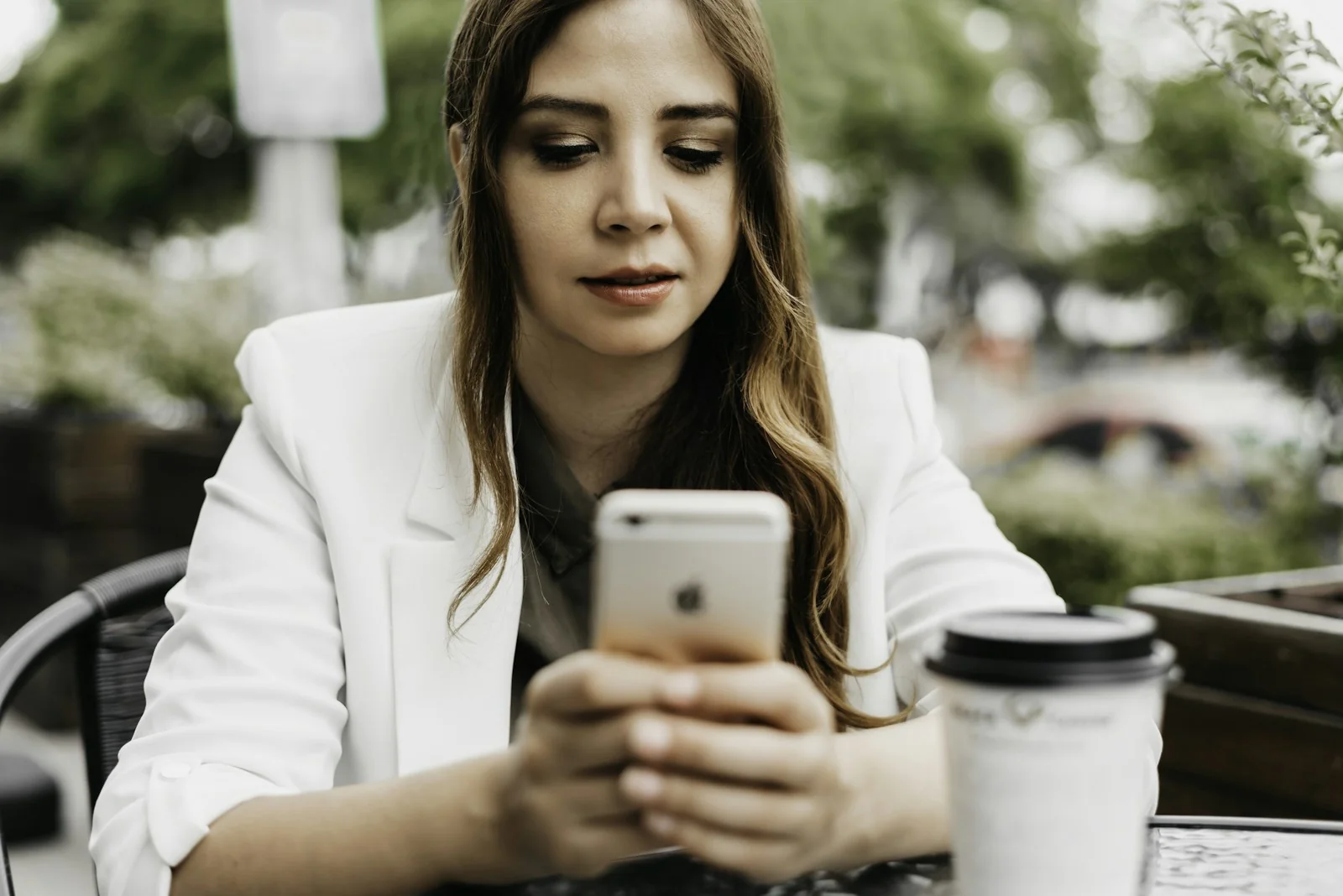 Perempuan memegang smartphone untuk mendaftar akun lelang online
