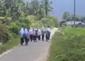 Rombongan siswi berseragam sekolah dan berjilbab putih berjalan pulang di jalan desa dekat sawah, tampak dari belakang
