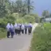 Rombongan siswi berseragam sekolah dan berjilbab putih berjalan pulang di jalan desa dekat sawah, tampak dari belakang