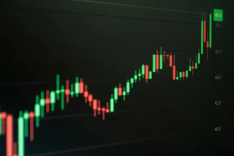 Grafik candlestick saham yang naik di layar