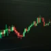 Grafik candlestick saham yang naik di layar