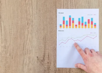 Grafik imbal hasil investasi di atas meja ilustrasi deposito vs P2P lending