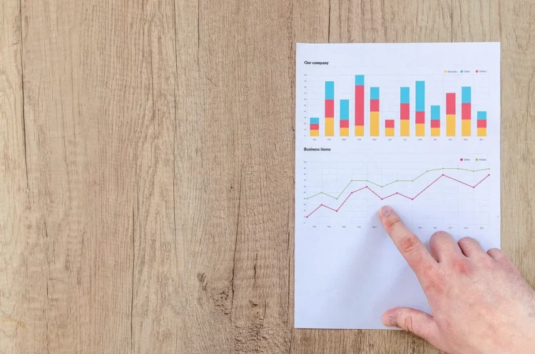 Grafik imbal hasil investasi di atas meja ilustrasi deposito vs P2P lending