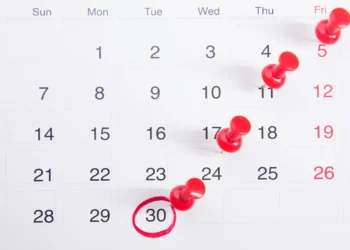 Kalender dengan paku pin merah penanda tanggal batas waktu