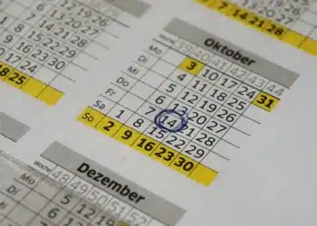 Kalender tahunan dengan tanggal 14 Oktober dilingkari tinta biru dan deretan hari Minggu ditandai kuning