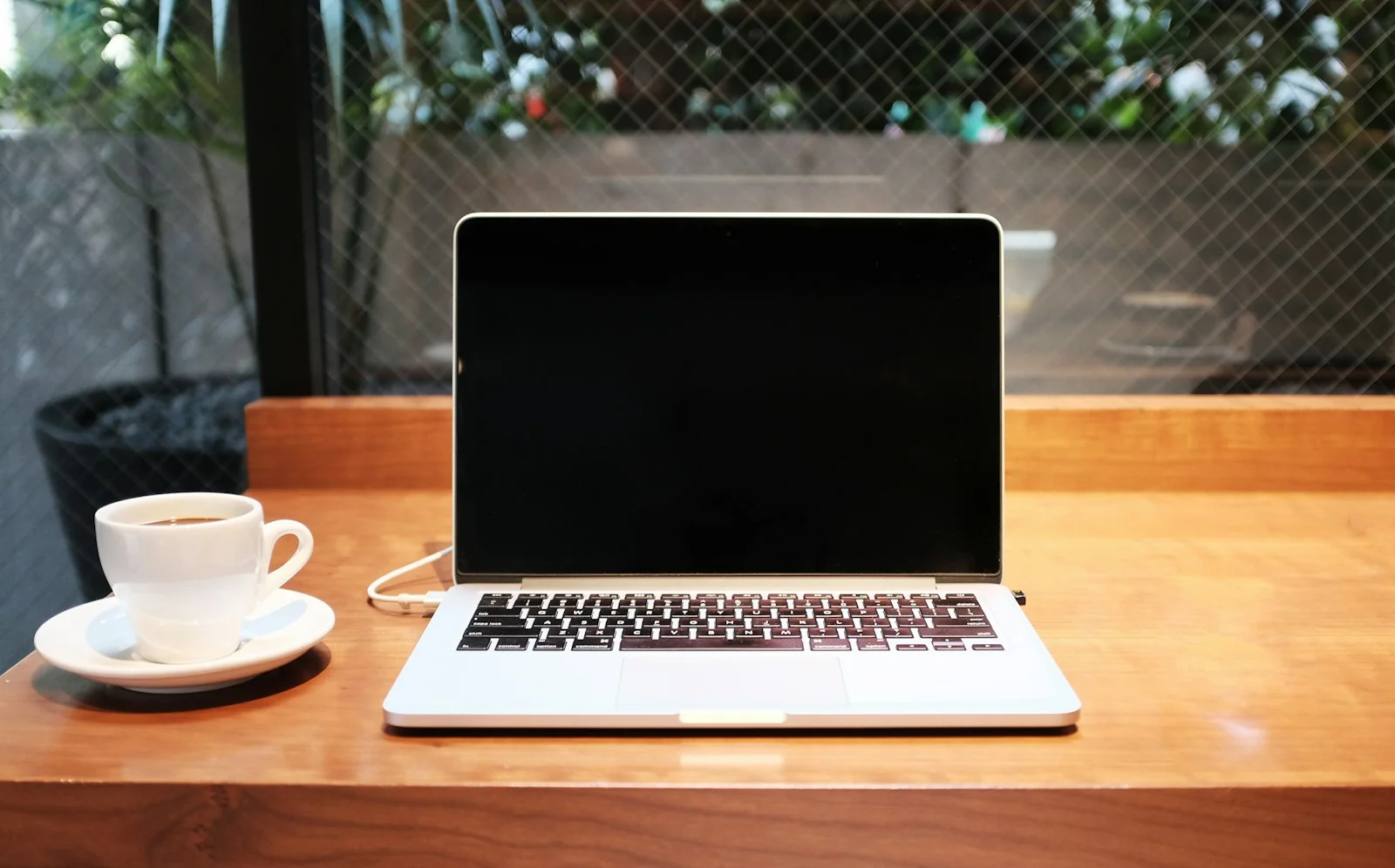 Laptop dan kopi di meja untuk mengecek laporan keuangan bank