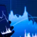 Ponsel dengan aplikasi saham di depan layar grafik