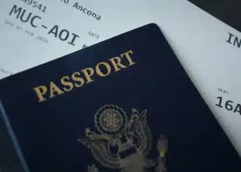 Paspor bersampul biru tua di atas tiket boarding pass penerbangan internasional