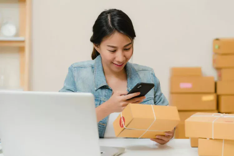 Pelaku usaha online memeriksa pesanan dan aplikasi bank di ponsel
