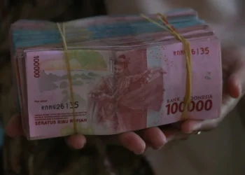 Tangan memegang uang rupiah pecahan Rp100.000