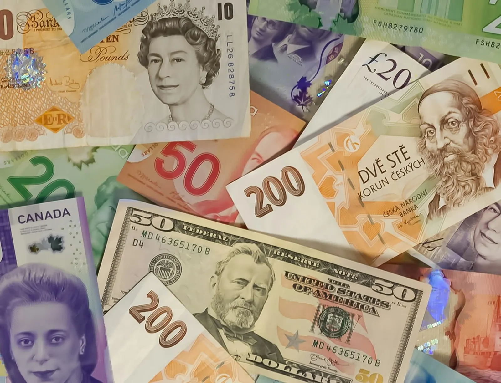 Uang kertas dolar AS, pound Inggris, dolar Kanada, dan koruna Ceko
