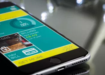 Ponsel pintar menampilkan aplikasi layanan keuangan di atas meja kaca