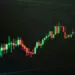 Grafik candlestick saham yang naik di layar