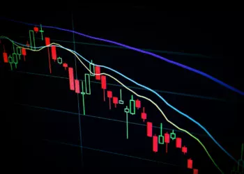 Grafik candlestick saham yang menurun di layar
