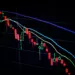 Grafik candlestick saham yang menurun di layar