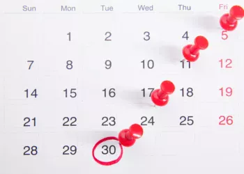 Kalender dengan paku pin merah penanda tanggal batas waktu