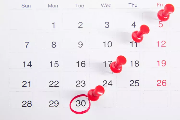 Kalender dengan paku pin merah penanda tanggal batas waktu