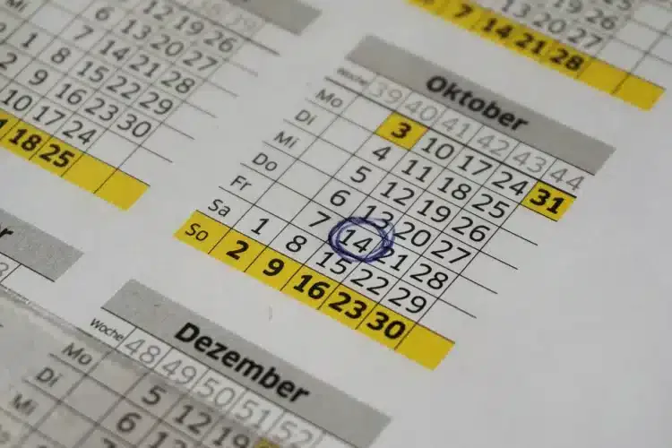 Kalender tahunan dengan tanggal 14 Oktober dilingkari tinta biru dan deretan hari Minggu ditandai kuning