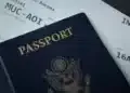 Paspor bersampul biru tua di atas tiket boarding pass penerbangan internasional