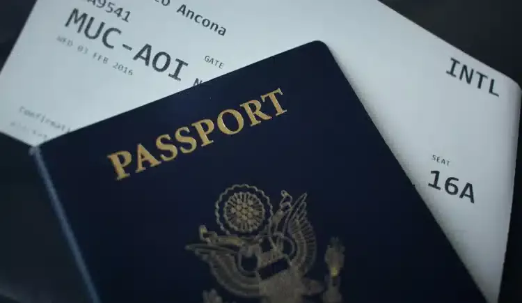Paspor bersampul biru tua di atas tiket boarding pass penerbangan internasional