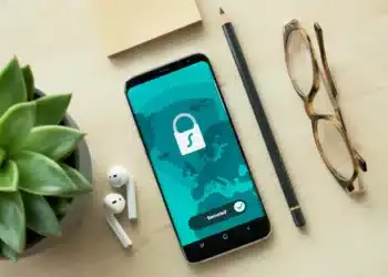 Ponsel menampilkan ikon gembok dan tulisan Secured di atas meja kayu