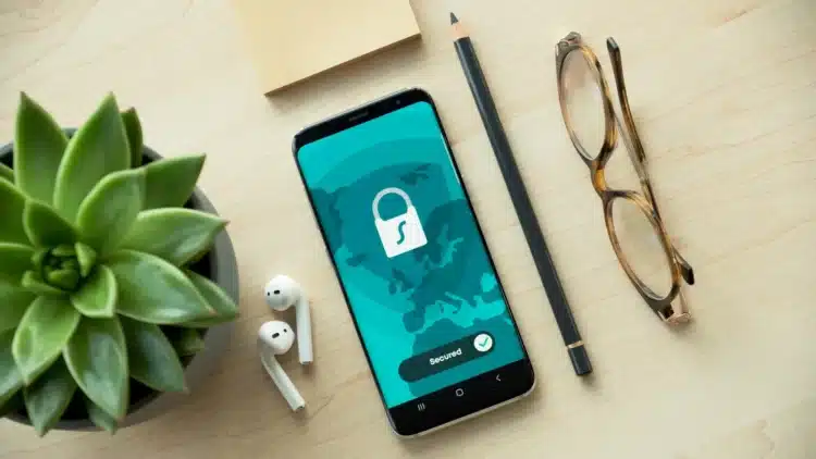 Ponsel menampilkan ikon gembok dan tulisan Secured di atas meja kayu