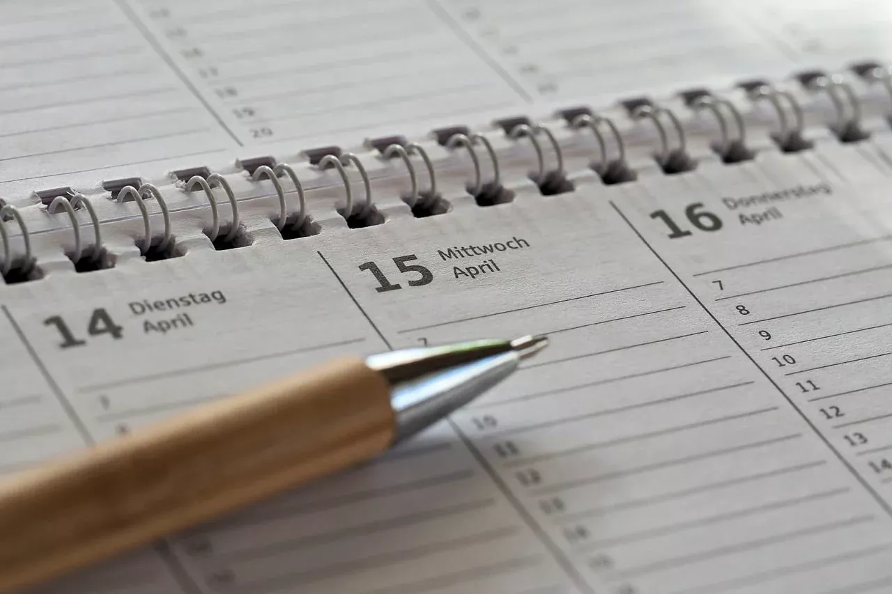 Agenda harian berspiral dan pulpen untuk mencatat jadwal jatuh tempo deposito