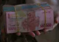 Tangan memegang uang rupiah pecahan Rp100.000